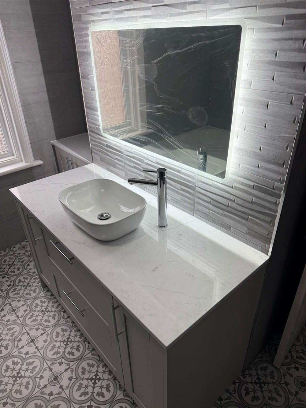 Vanity unit with countertop basin and patterned floor tiles