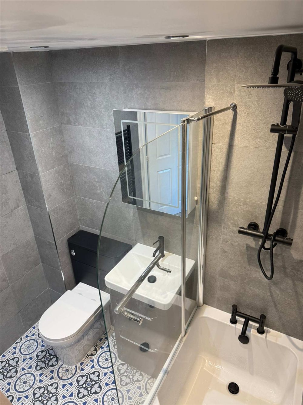 Compact bathroom with glass shower screen and black fittings