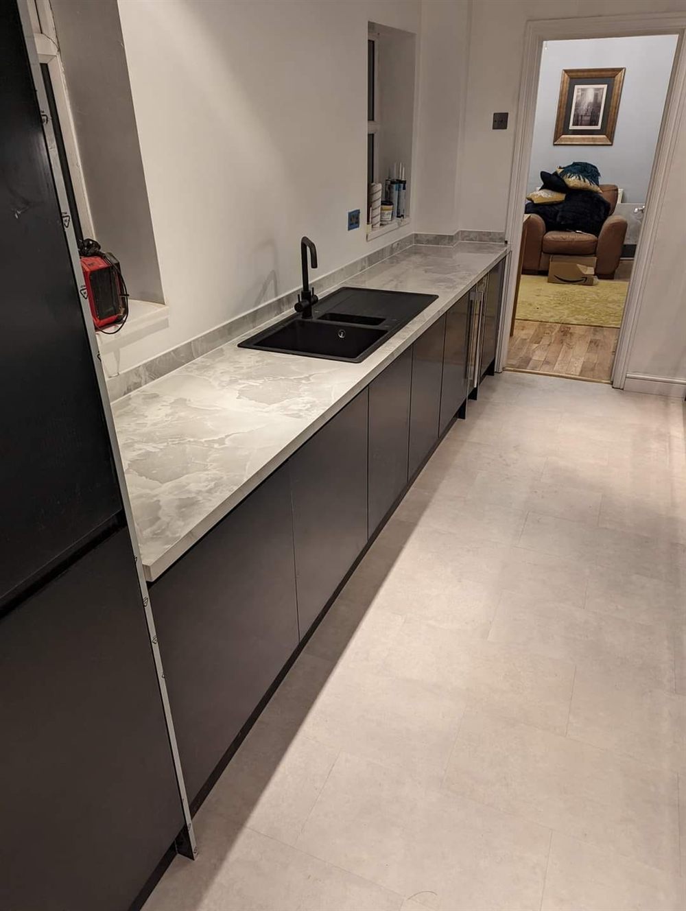 Dark handleless kitchen with marble-effect worktop
