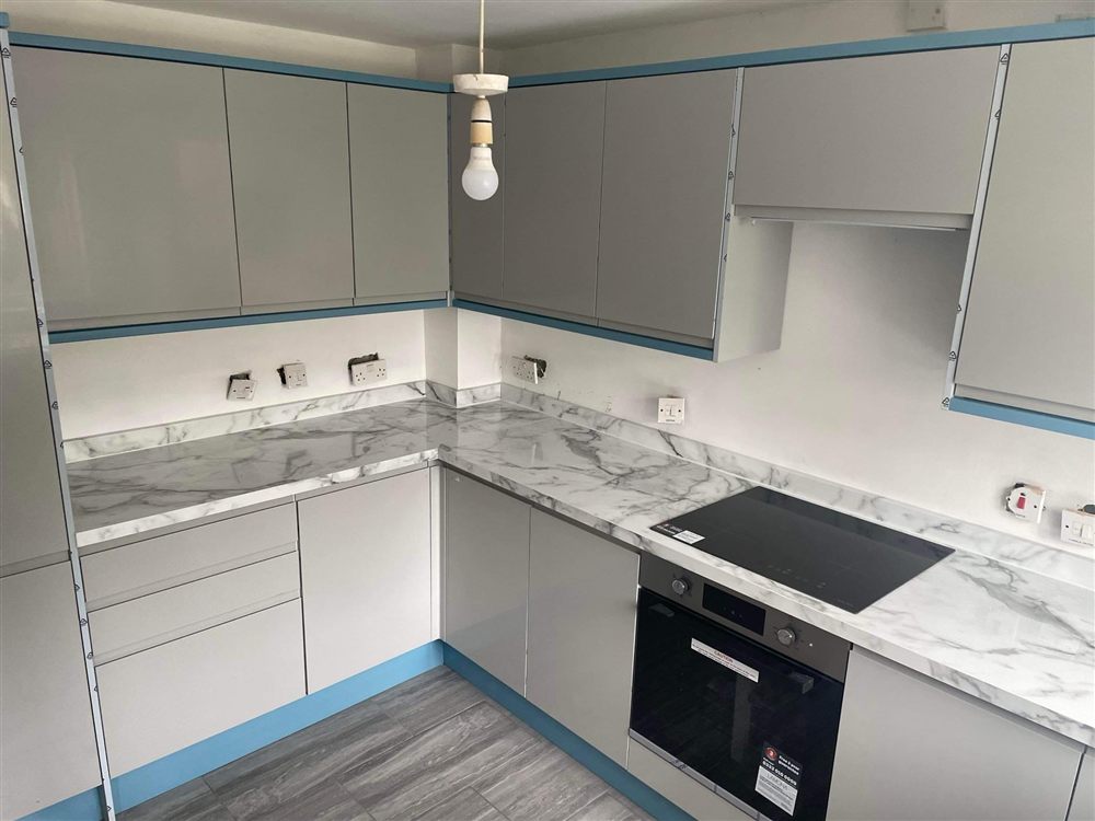 Grey kitchen installation with marble-effect worktops