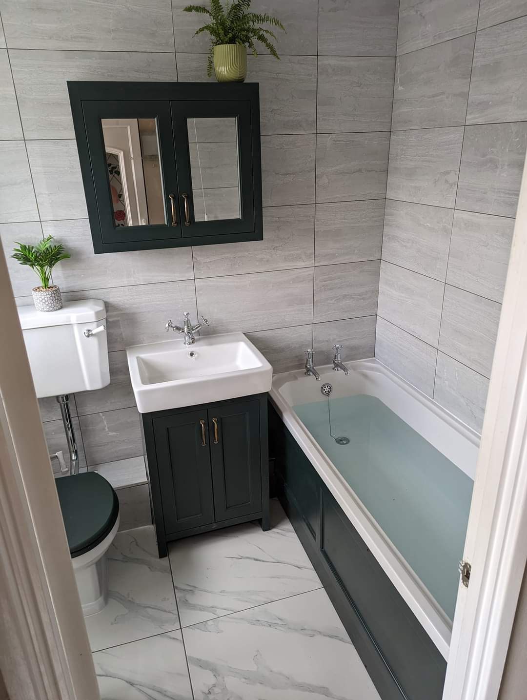 Bathroom with dark green vanity and marble floor