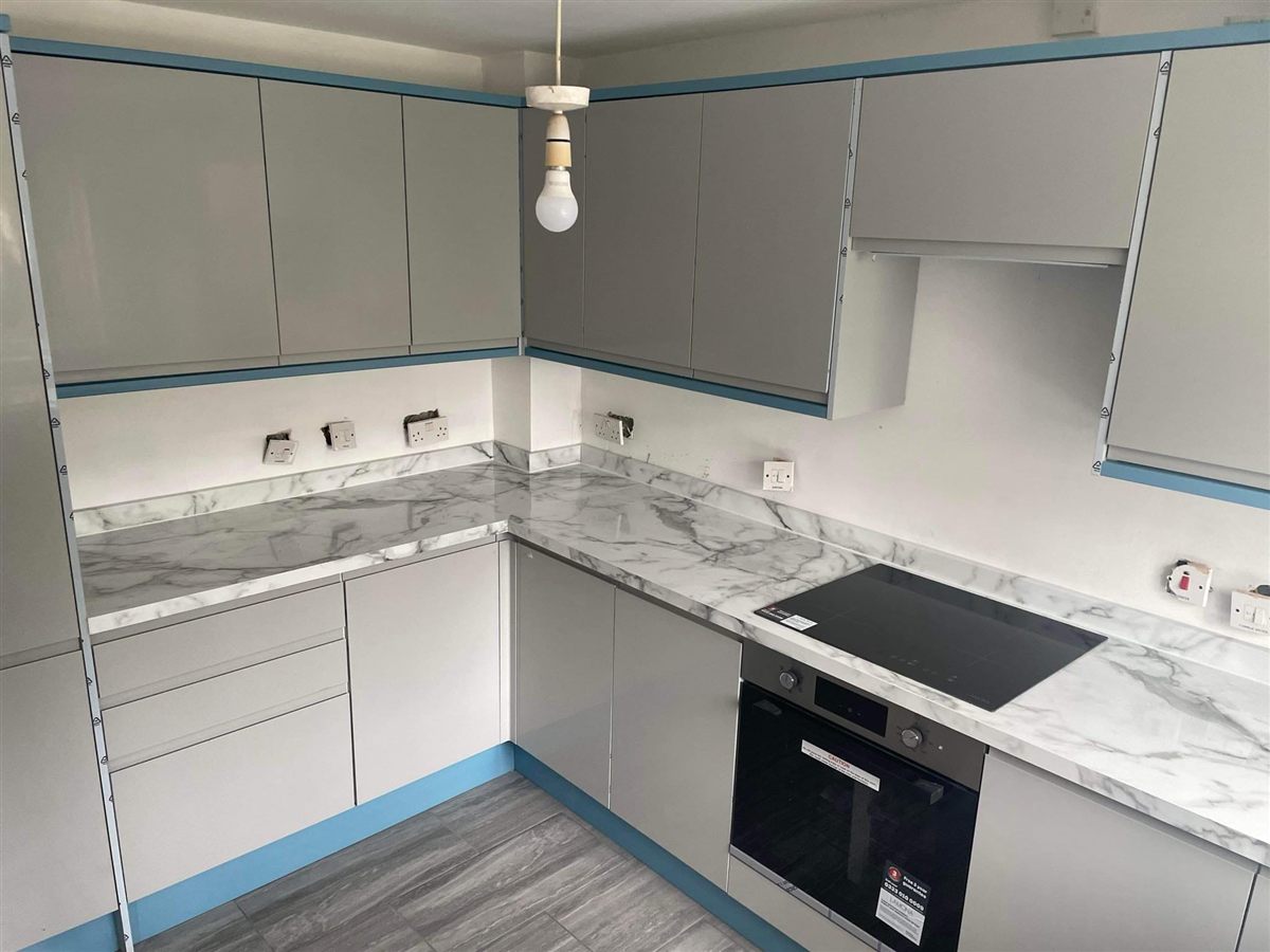 Grey handleless kitchen with marble-effect worktops